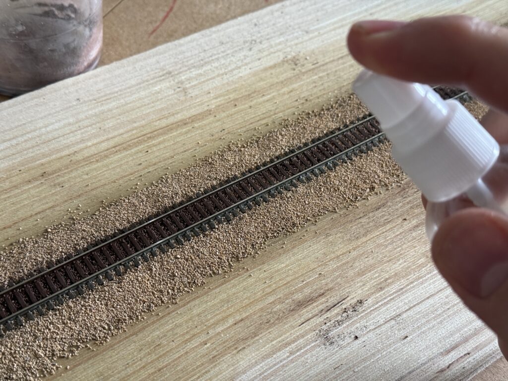 Misting the track to set the weathering powders