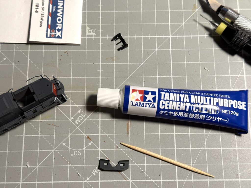 Repainting a locomotive: suing Tamiya Multipurpose Cement (Clear) glue to secure the snow plow in place