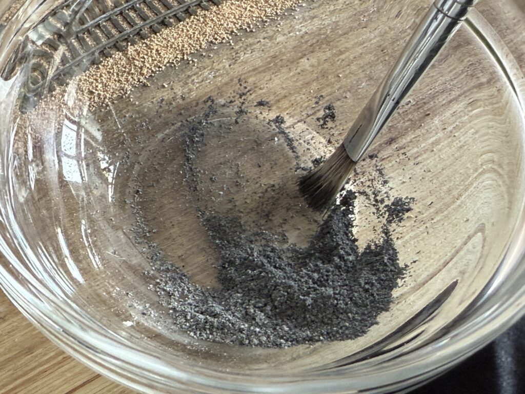Black powdered pigments and plaster of Paris mixed with a brush