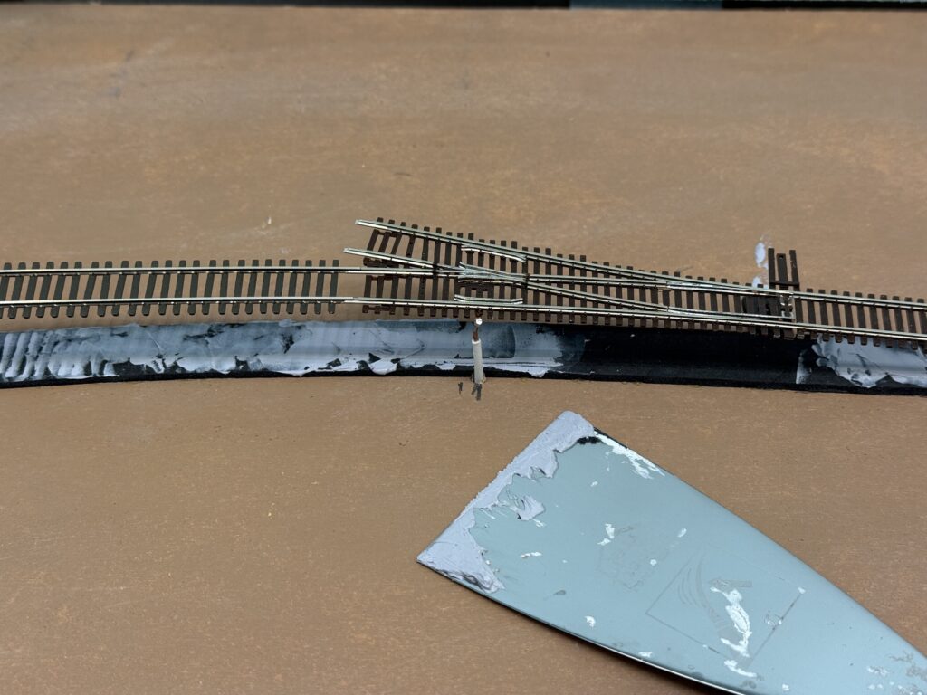Using acrylic caulk to glue track down.